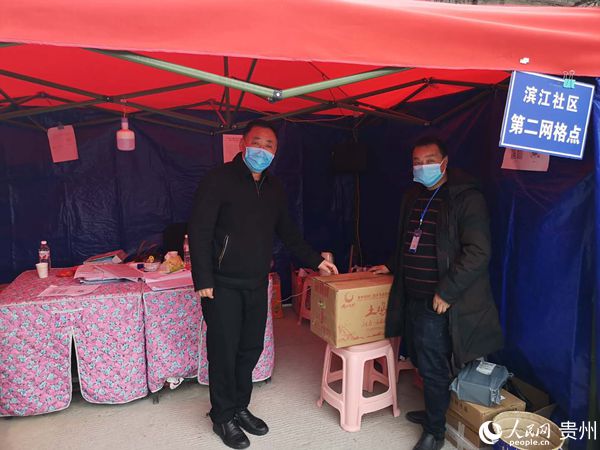 松桃苗族自治县人大常委会副主任张德沛（左）到时代天街小区看望慰问机关工作人员并赠送口罩、鸡蛋等防控物资。